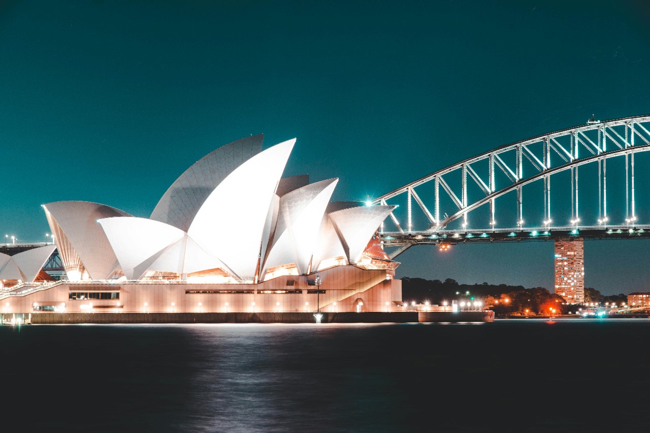 Sydney Opera House and Harbour Bridge illuminated at night, showcasing Australia's iconic landmarks and world-class education system with beautiful harbor views