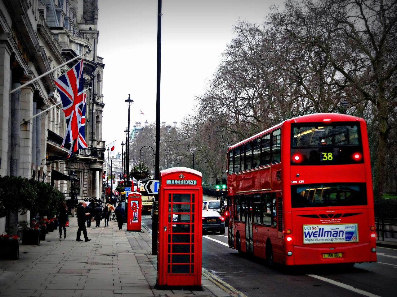 Classic London street scene with iconic red telephone box, double-decker bus, and Union Jack flags, representing the UK's rich cultural heritage and world-class education system